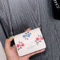 MINI BOLSO COACH BLANCO CON FLORES