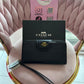 BILLETERA COACH NEGRA CON RELIEVE