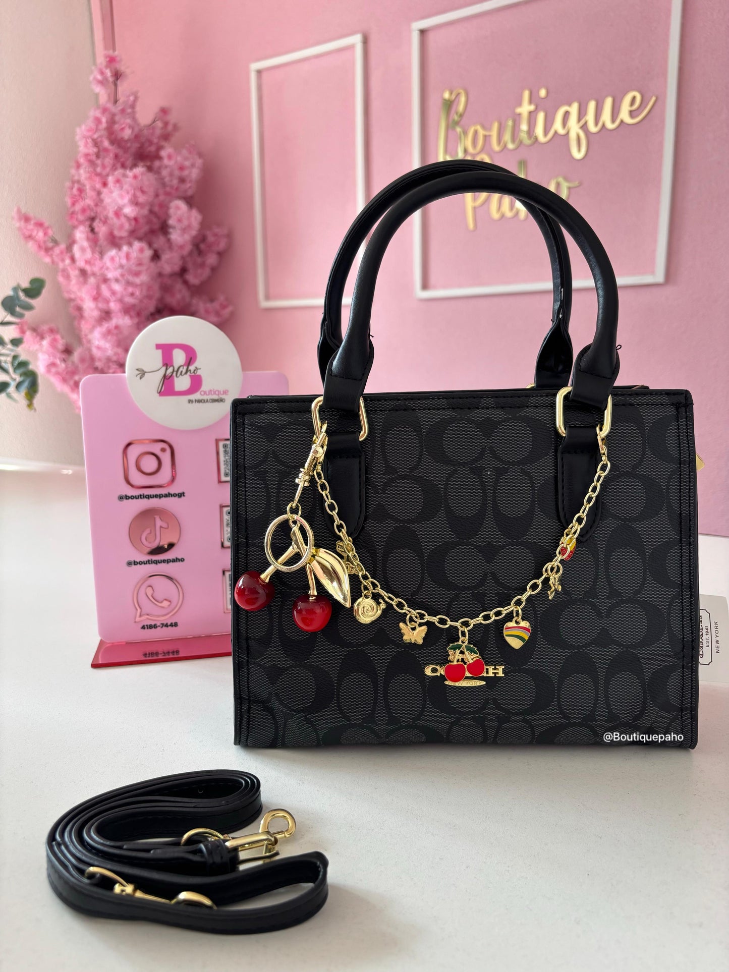CARTERA COACH NEGRA CON CHARM DE CEREZA Y CADENA